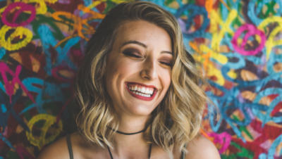 Woman laughing in front of colorful wall